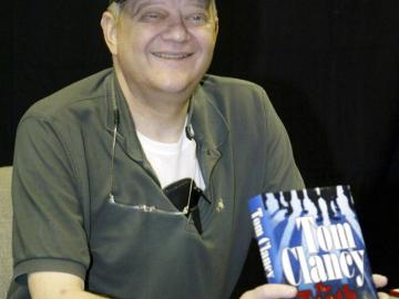 Tom Clancy posando con su libro 'Los dientes del tigre'