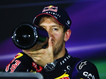 Vettel bebe champán en la rueda de prensa