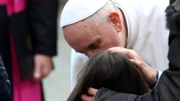 El Papa besa a una los visitantes