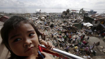 Una niña mira los escombros del tifón Haiyán