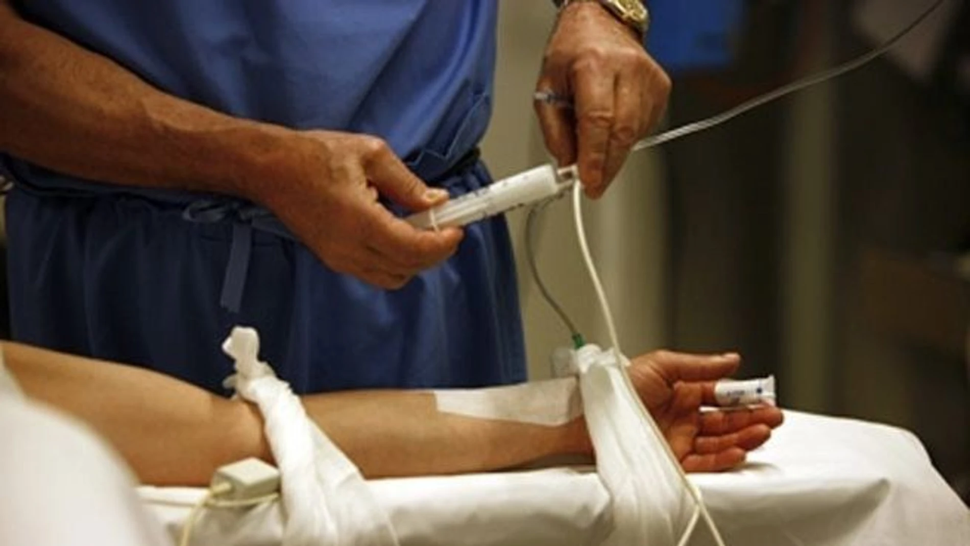 Un sanitario administra fármacos a un paciente. Un sanitario administra fármacos a un paciente.