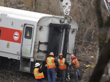 Empleados trabajan para retirar el último vagón del lugar del accidente