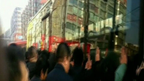 Un grupo de chinos levanta un autob&uacute;s