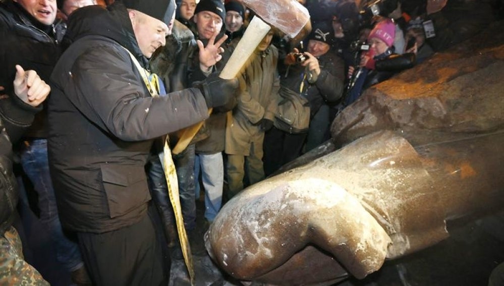 Los opositores ucranios golpean una estatua de Lenin