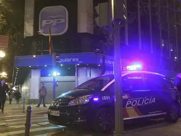 Un coche de la Policía estacionado en el exterior de la sede del PP Un coche de la Policía estacionado en el exterior de la sede del PP