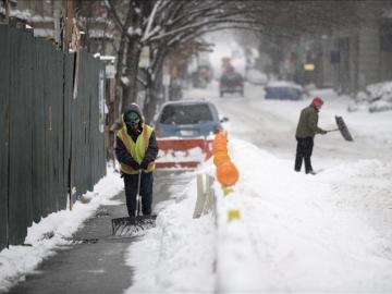 Un obrero retira la nieve acumulada frente a la obra en la que trabaja en Nueva York