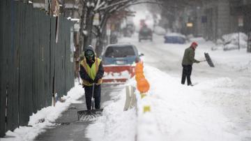Un obrero retira la nieve acumulada frente a la obra en la que trabaja en Nueva York