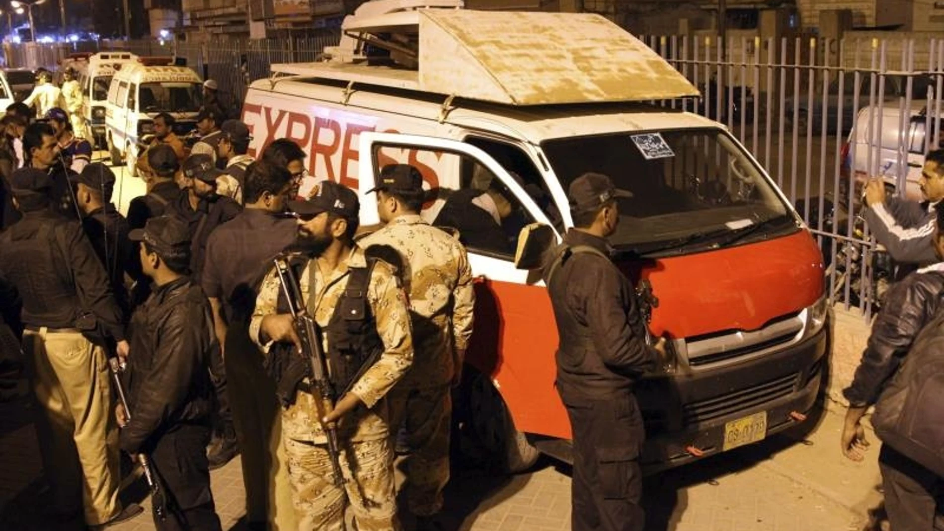 Varios agentes de seguridad inspeccionan el vehículo de un canal de televisión local asaltado en Karachi. Varios agentes de seguridad inspeccionan el vehículo de un canal de televisión local asaltado en Karachi.