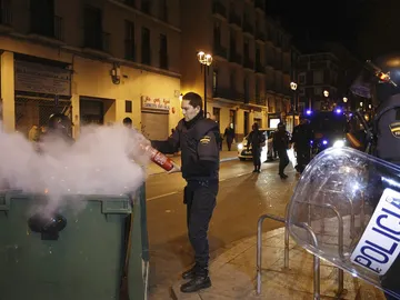 Un Policía Nacional apaga un contenedor quemado Un Policía Nacional apaga un contenedor quemado