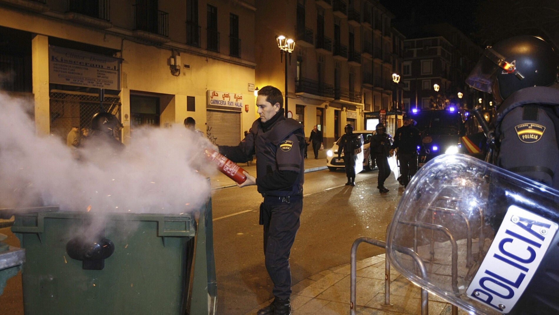 Un Polic&iacute;a Nacional apaga un contenedor quemado