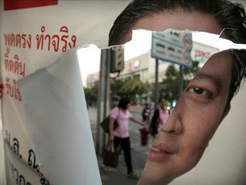 Cartel electoral roto con la imagen de Yingluck Shinawatra 
