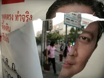 Cartel electoral roto con la imagen de Yingluck Shinawatra Cartel electoral roto con la imagen de Yingluck Shinawatra
