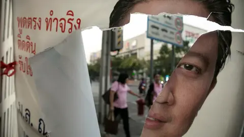 Cartel electoral roto con la imagen de Yingluck Shinawatra Cartel electoral roto con la imagen de Yingluck Shinawatra