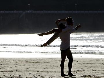  Dos jóvenes disfrutan del atardecer en la playa de La Concha de San Sebastián