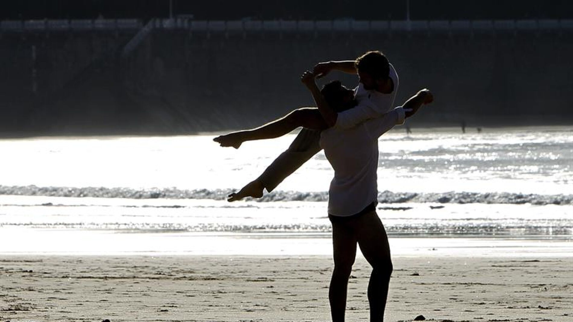  Dos j&oacute;venes disfrutan del atardecer en la playa de La Concha de San Sebasti&aacute;n
