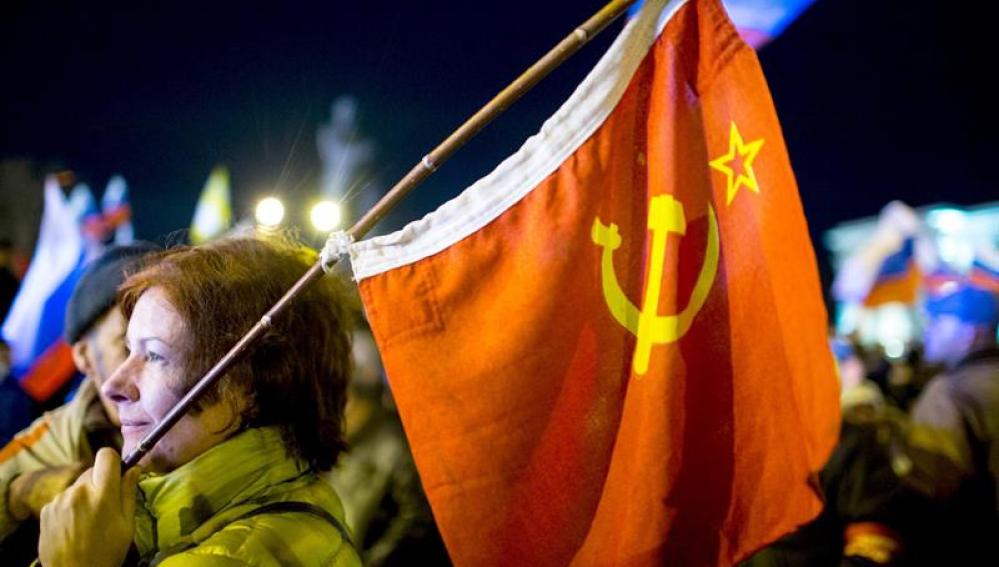 Una mujer sostiene una bandera de la época soviética