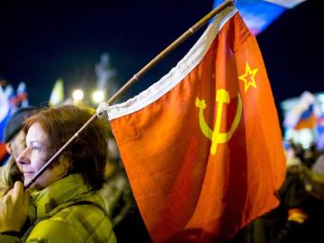 Una mujer sostiene una bandera de la época soviética