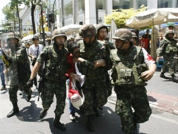 Soldados detienen a un insurgente en las calles de Tailandia.