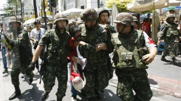 Soldados detienen a un insurgente en las calles de Tailandia.