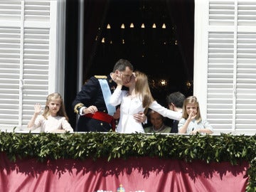 La Reina besa al Rey en el balcón