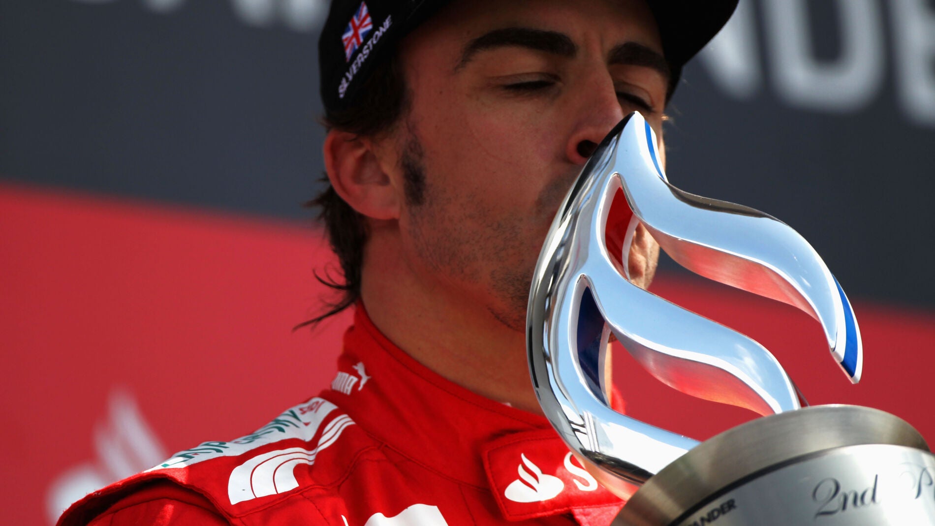 Fernando Alonso besa un trofeo en el podio
