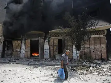 Un palestino abandona su casa en llamas Un palestino abandona su casa en llamas