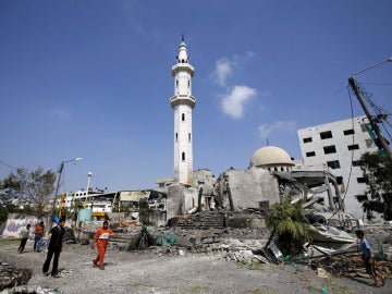 Palestinos caminando cerca de una mezquita