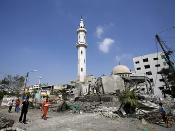 Palestinos caminando cerca de una mezquita Palestinos caminando cerca de una mezquita