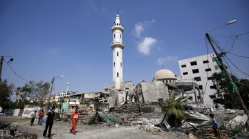 Palestinos caminando cerca de una mezquita