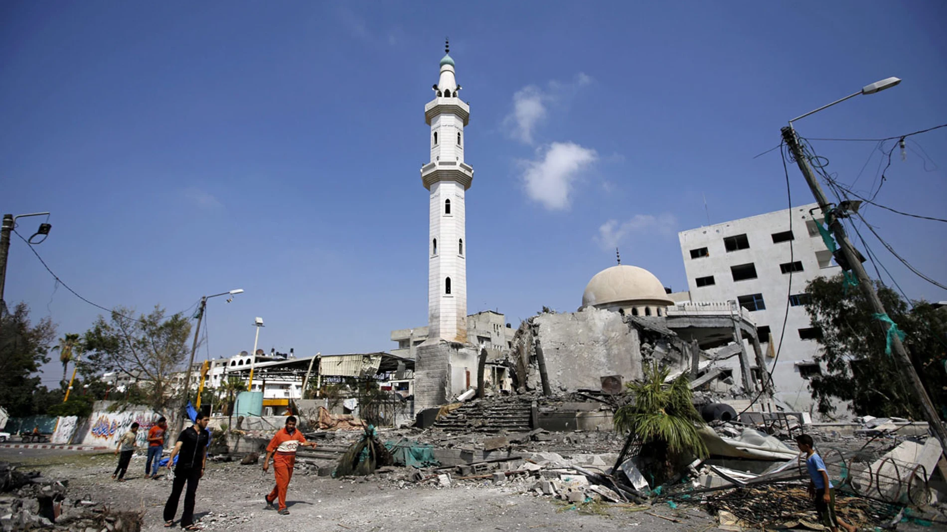 Palestinos caminando cerca de una mezquita Palestinos caminando cerca de una mezquita