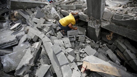 Un palestino busca entre los escombros tras un bombardeo israel&iacute;