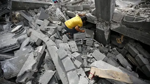 Un palestino busca entre los escombros tras un bombardeo israelí Un palestino busca entre los escombros tras un bombardeo israelí