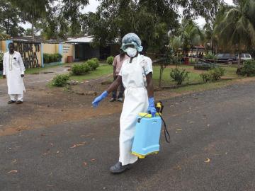 Una enfermera esparce desinfectante en las inmediaciones de un hospital