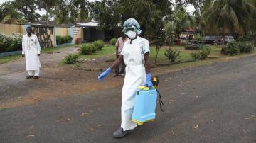 Una enfermera esparce desinfectante en las inmediaciones de un hospital