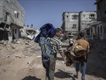 Ciudadanos palestinos caminando sobre ruinas Ciudadanos palestinos caminando sobre ruinas