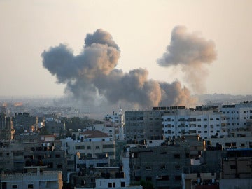 Una columna de humo se levanta por encima de los edificios en la ciudad de Gaza