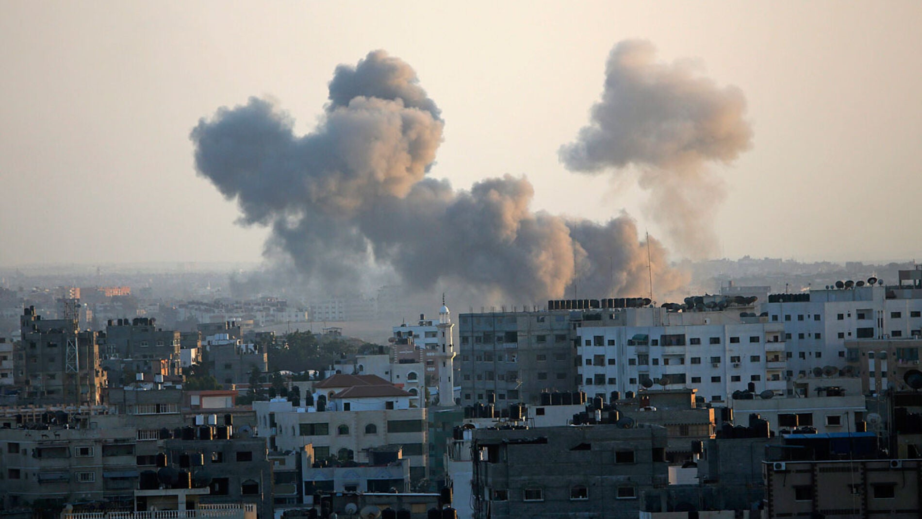 Una columna de humo se levanta por encima de los edificios en la ciudad de Gaza