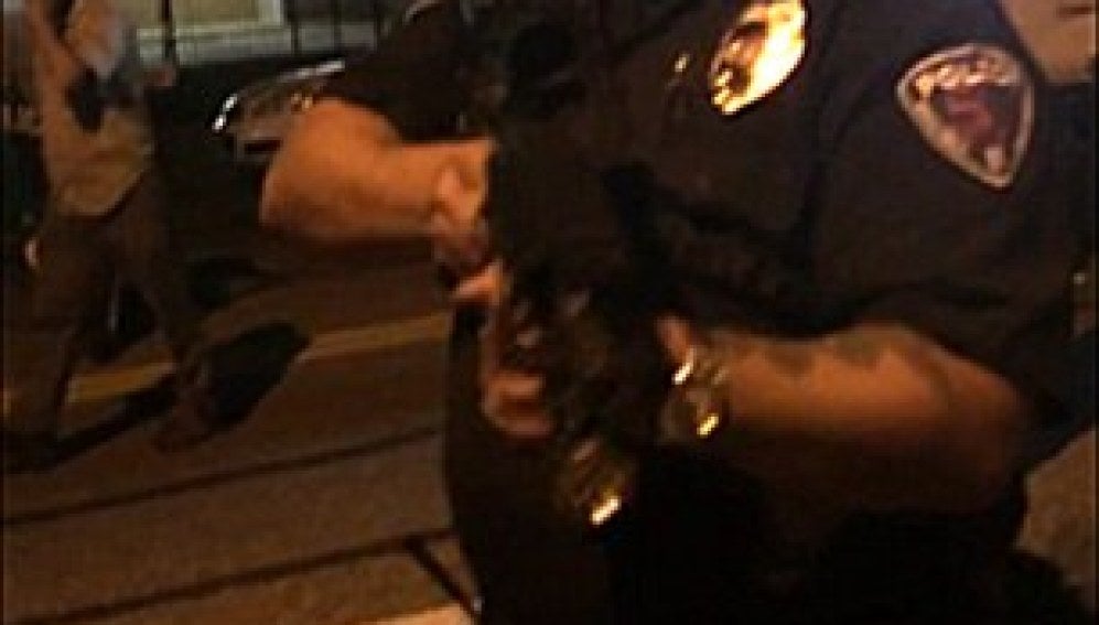 Cesan a un policía por grabar a los manifestantes mientras les apuntaba con un rifle en Ferguson