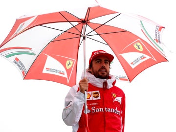 Fernando Alonso, protegido por un paraguas