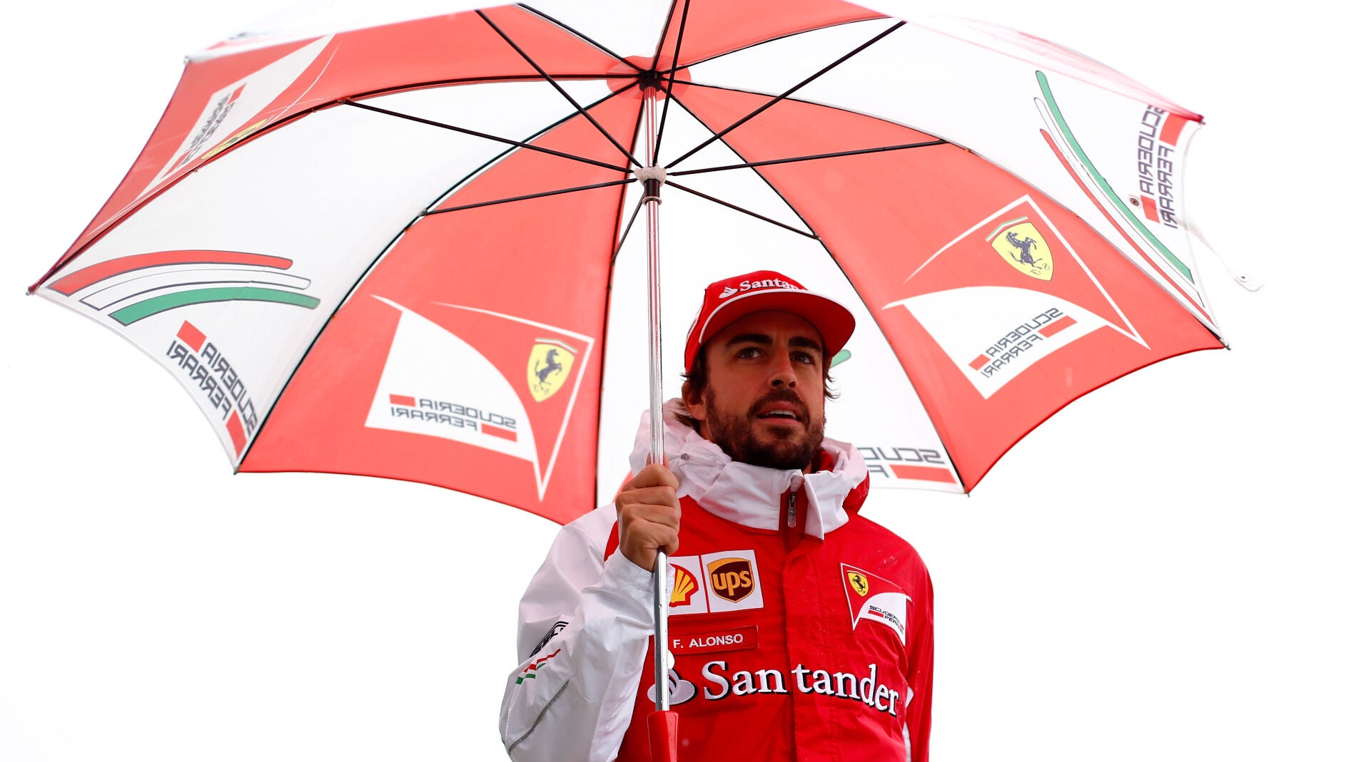 Fernando Alonso, protegido por un paraguas