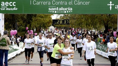Dos participantes se abrazan en la meta de la carrera organizada por la AECC en Madrid