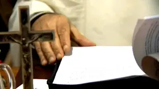 Un religioso con documentos y un crucifijo Un religioso con documentos y un crucifijo
