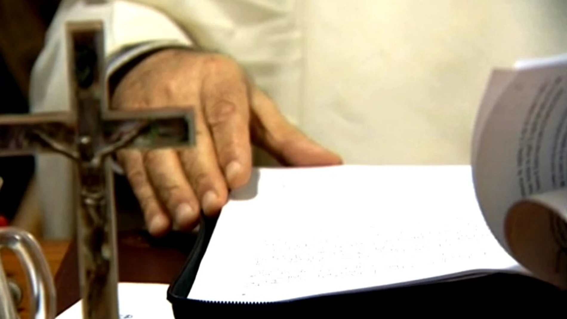 Un religioso con documentos y un crucifijo Un religioso con documentos y un crucifijo