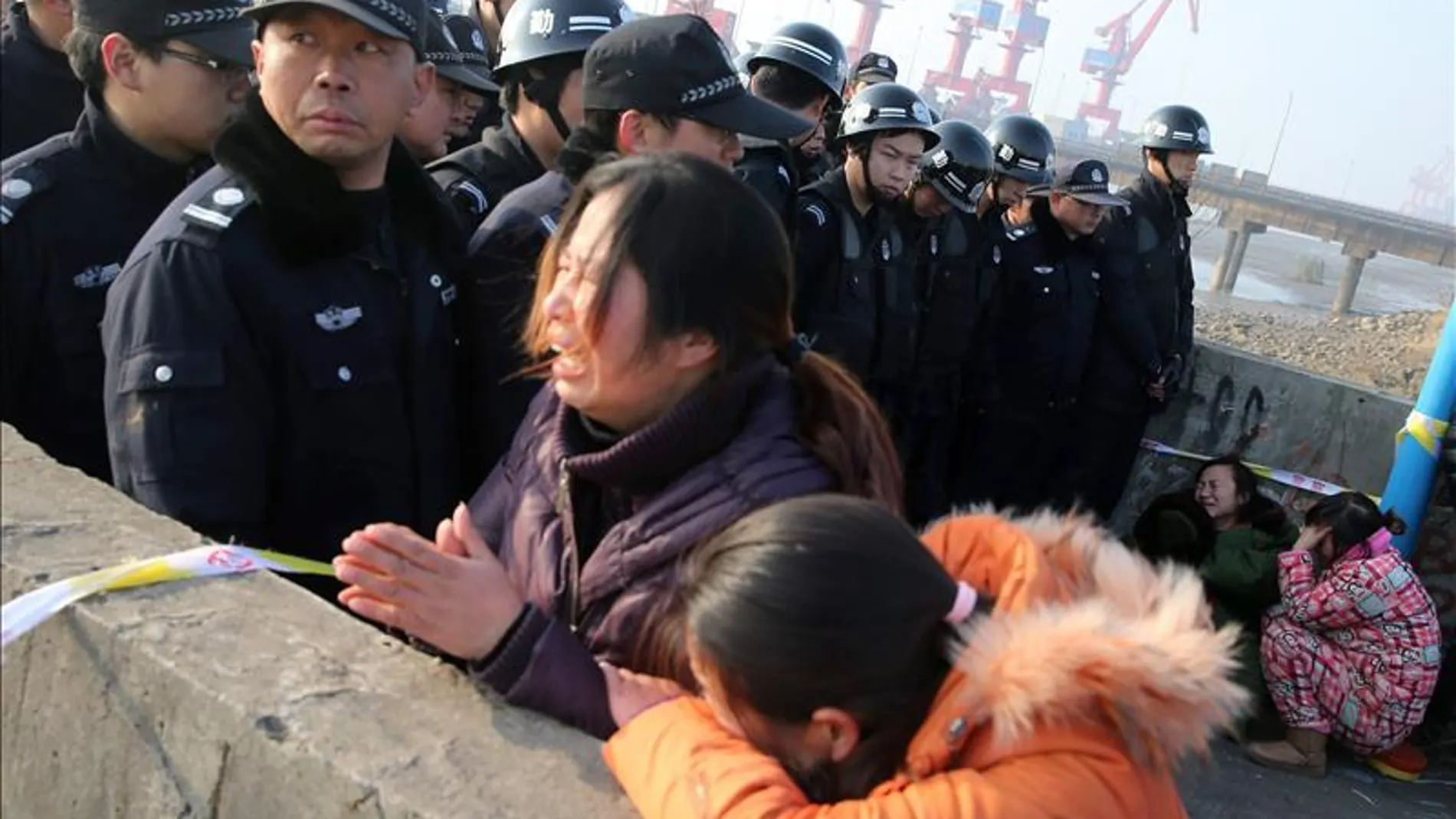 Familiares de los fallecidos en el puerto del río Yangtsé. Familiares de los fallecidos en el puerto del río Yangtsé.