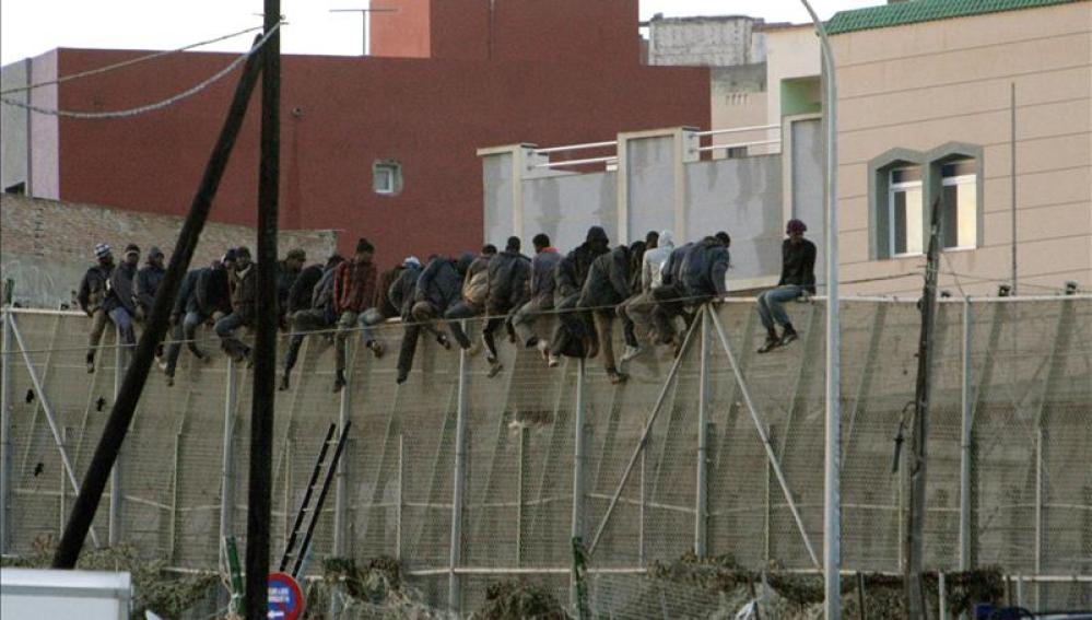 Imagen de unos inmigrantes encaramados en la valla de Melilla el pasado mes de diciembre.