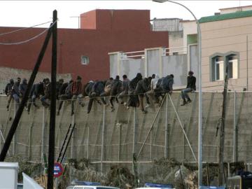 Imagen de unos inmigrantes encaramados en la valla de Melilla el pasado mes de diciembre.
