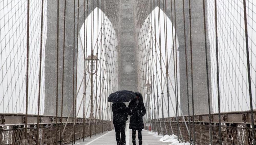 Caminando bajo la nieve en el puente de Brooklyn.