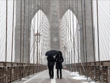 Caminando bajo la nieve en el puente de Brooklyn.