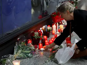 Una mujer enciende una vela en el monumento a las víctimas en Atocha Una mujer enciende una vela en el monumento a las víctimas en Atocha