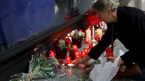 Una mujer enciende una vela en el monumento a las víctimas en Atocha Una mujer enciende una vela en el monumento a las víctimas en Atocha